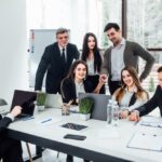Une équipe diversifiée de professionnels collaborant activement dans un espace de bureau moderne et lumineux, illustrant le dynamisme de l'entreprise
