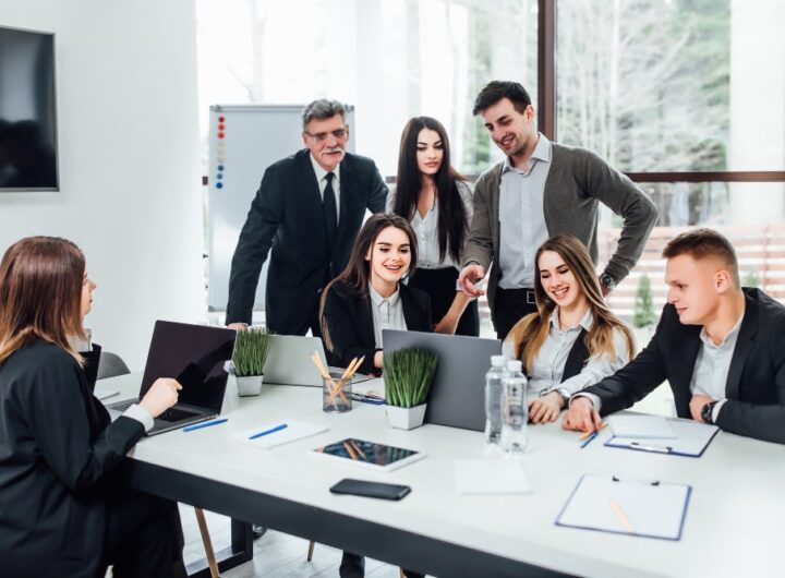 Une équipe diversifiée de professionnels collaborant activement dans un espace de bureau moderne et lumineux, illustrant le dynamisme de l'entreprise
