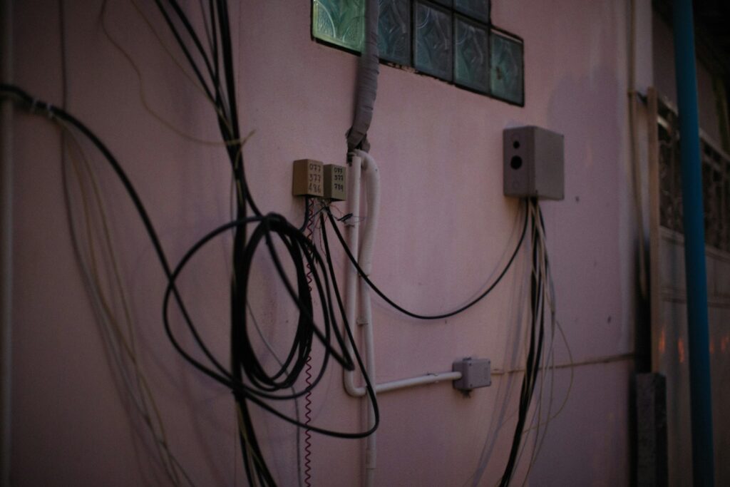 a bunch of wires hanging on the side of a building